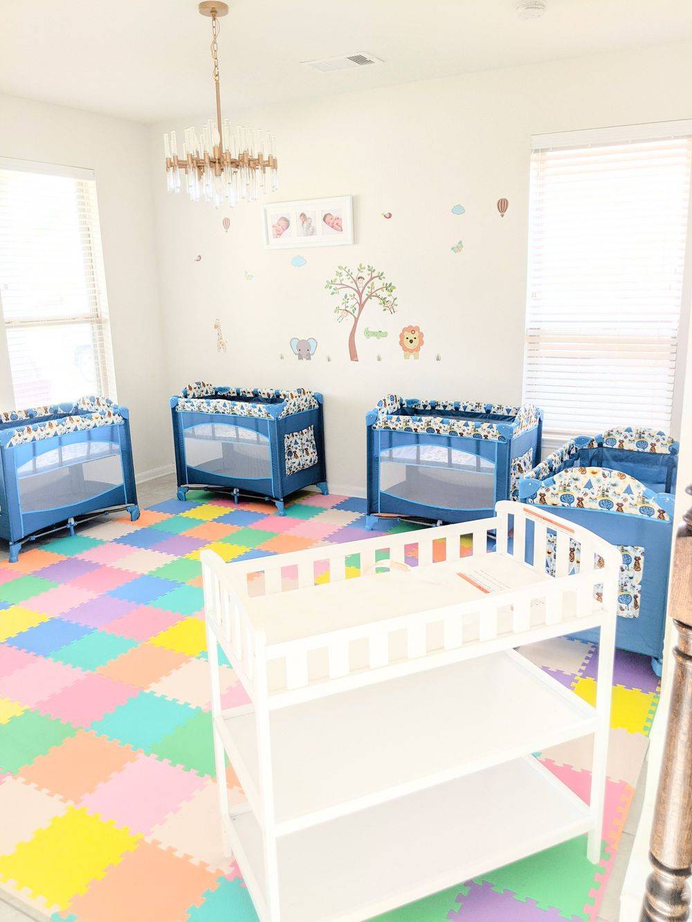 Bright infant room with cribs and a colorful play mat
